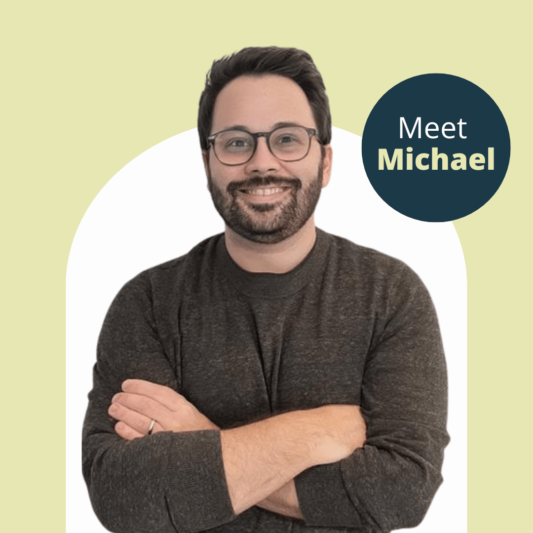 Picture of Michael Tankenoff, our New Executive Director. He is crossing his arms on a green background with a white curved shape behind him.